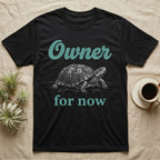 Box Turtle Owner T-Shirt in Black — White engraved eastern box turtle walking forward between the word Owner in teal script and for now in teal serif type.