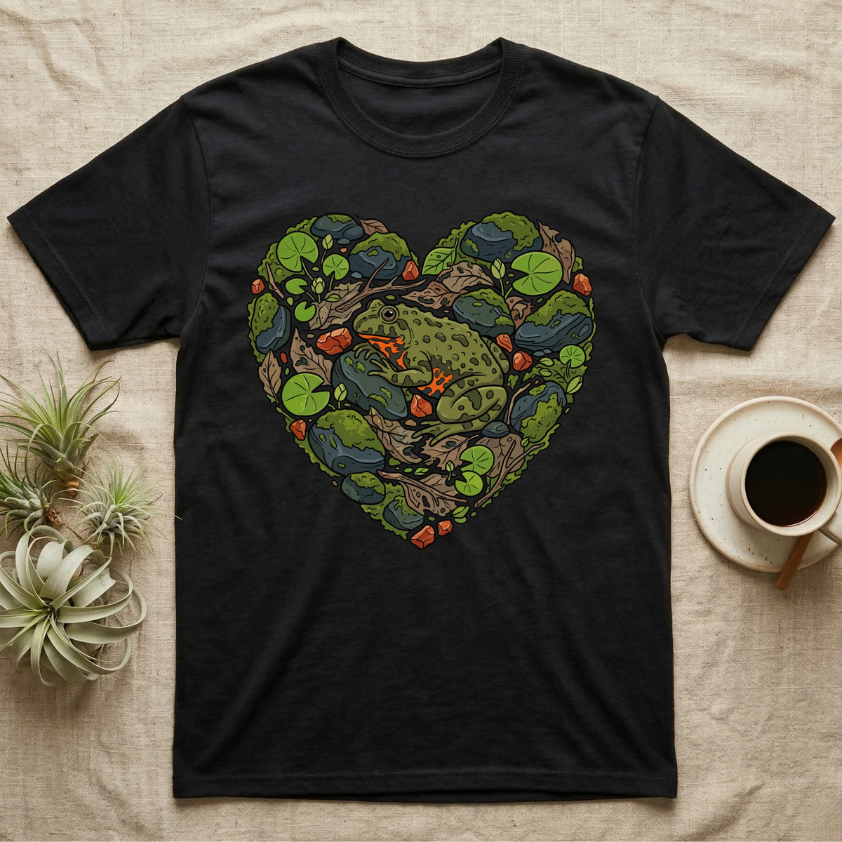 Black t-shirt with a green frog and moss heart design.