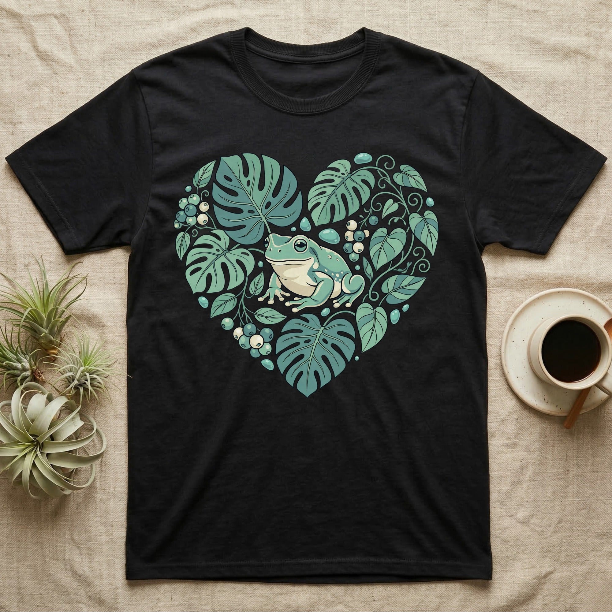 Black t-shirt with a heart-shaped design of monstera leaves and a frog.