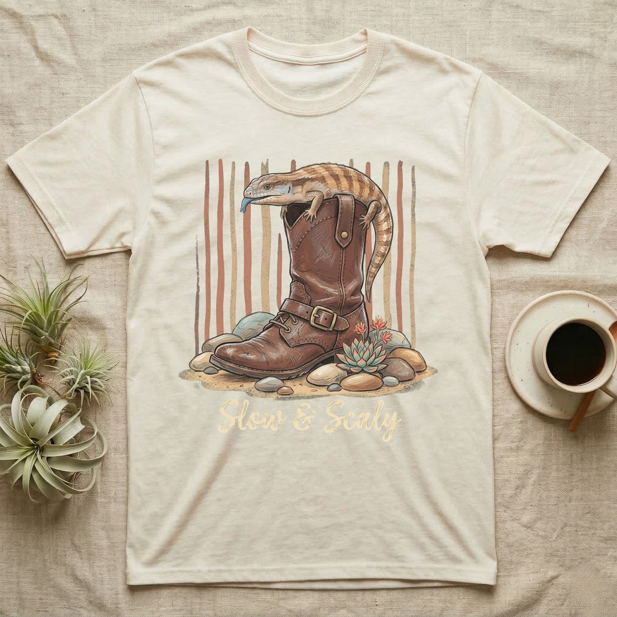 Cream t-shirt with a lizard on a boot, "Slow & Scaly" text.