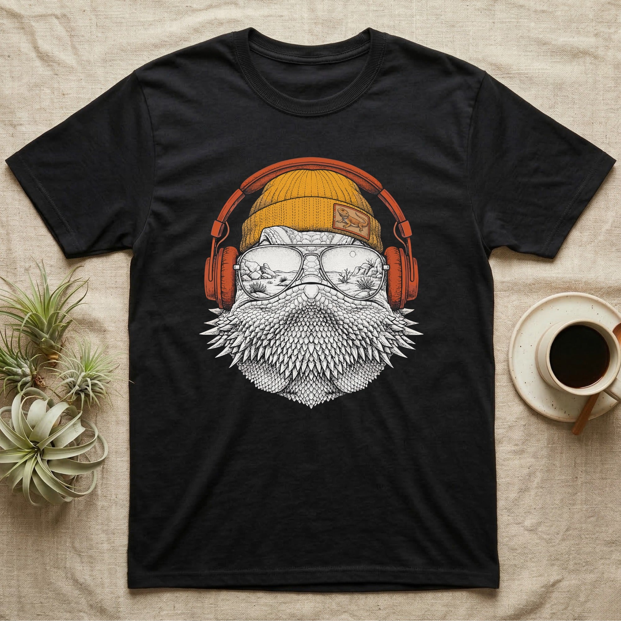 Bearded Dragon Headphones T-Shirt in Black — Engraved bearded dragon with spiked beard in a beanie and headphones, aviators reflecting a desert canyon.