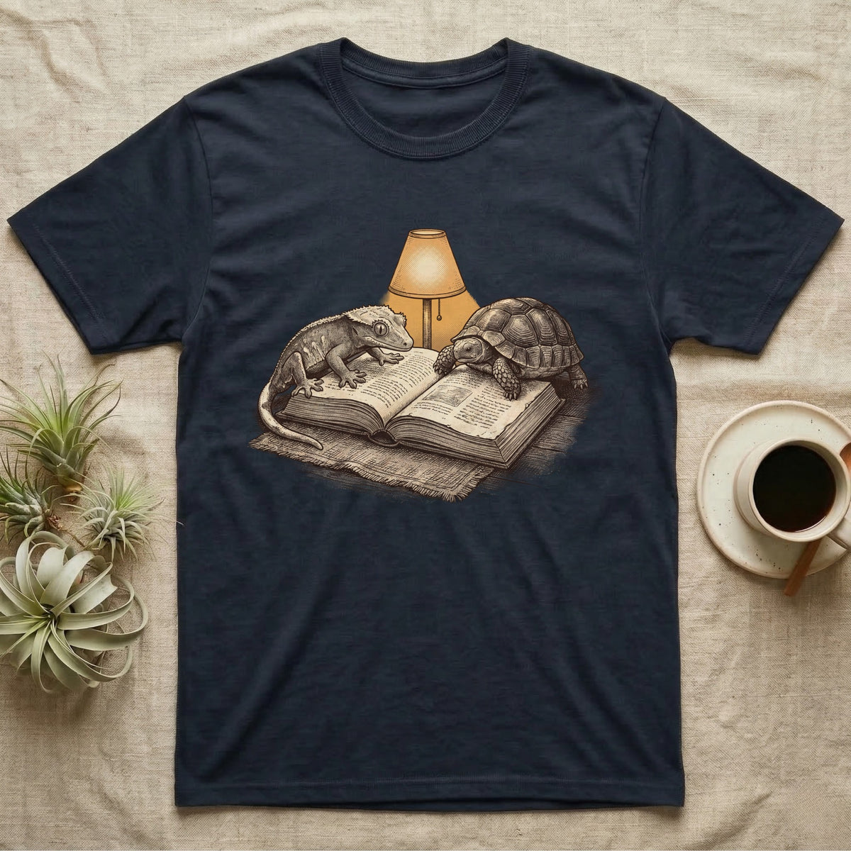 Cold-Blooded Book Club T-Shirt in Navy — Engraved cozy illustration of a gecko and a tortoise sharing an open book under a glowing reading lamp.