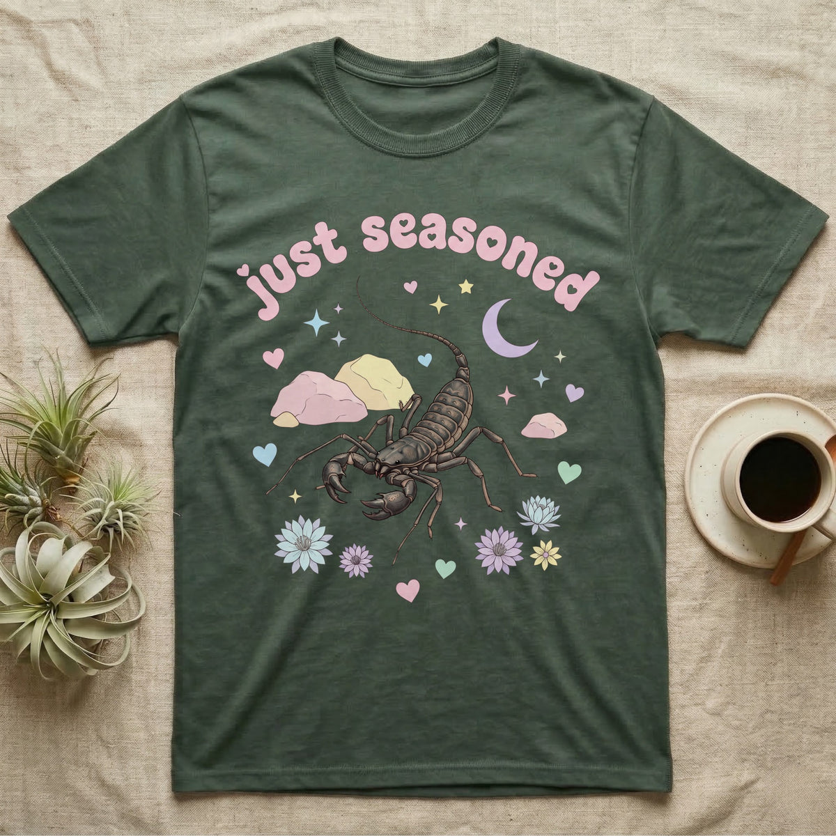 Giant Vinegaroon Baby T-Shirt in Military Green — Pastel giant vinegaroon with pincers and whip tail among rocks and a crescent moon, puffy pink wordmark "just seasoned" above.