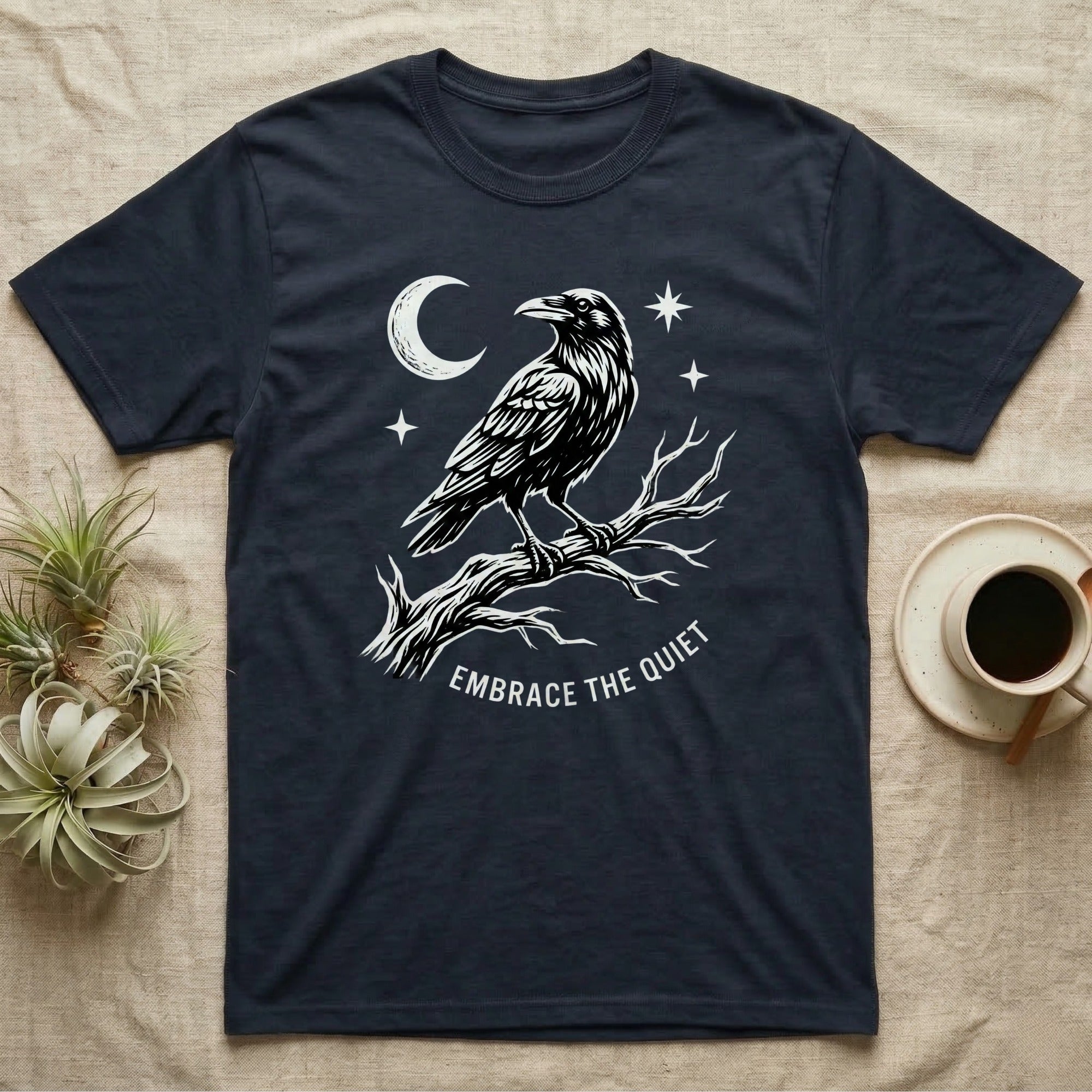 Dark t-shirt with white raven and moon design, "EMBRACE THE QUIET" text.