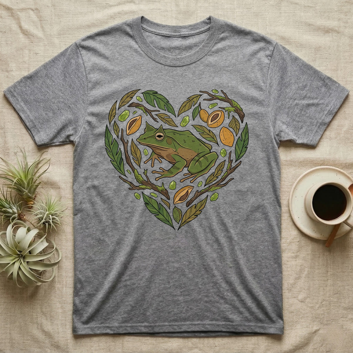 Grey t-shirt with a green frog in a heart-shaped leaf and fruit design.