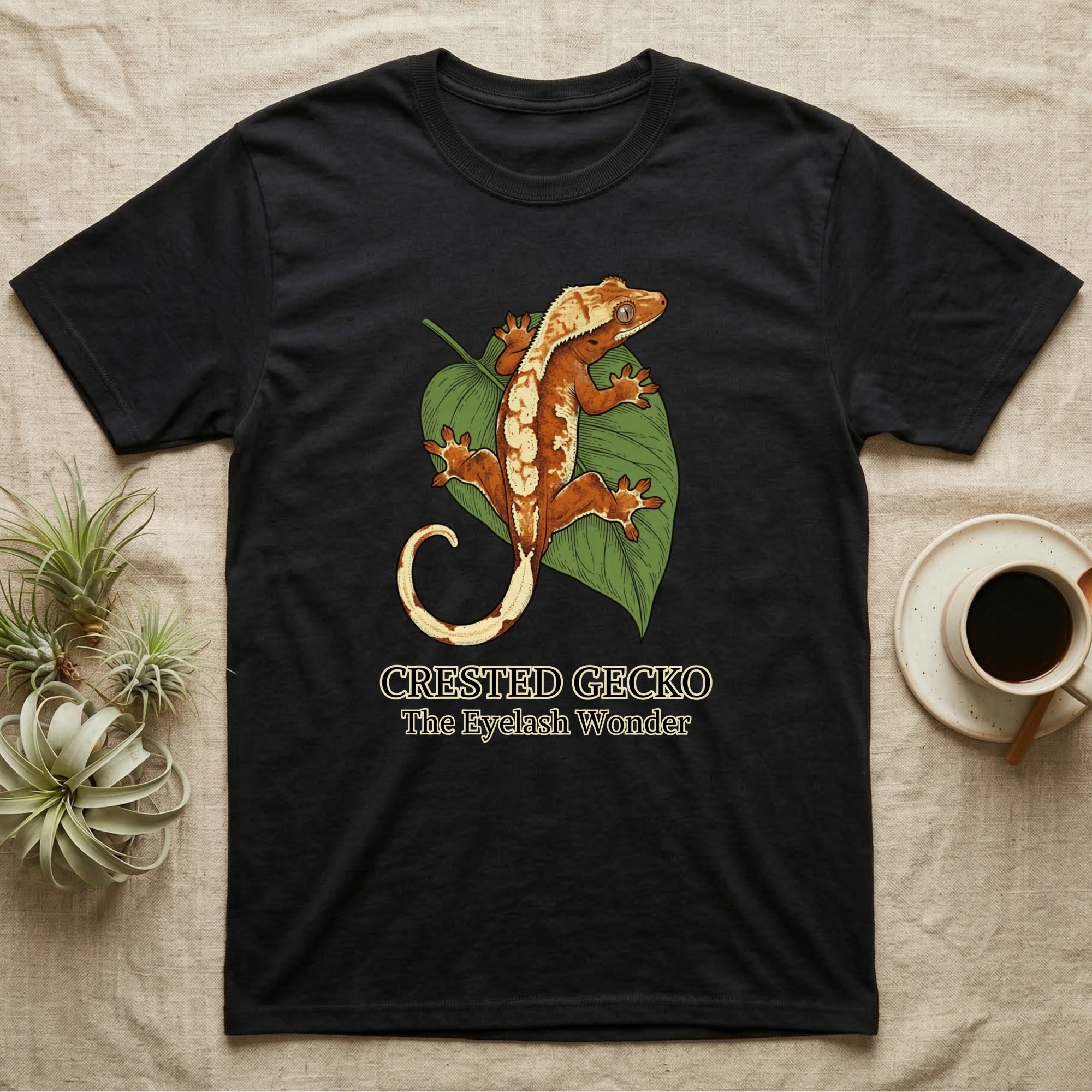 Black t-shirt featuring a crested gecko on a leaf.