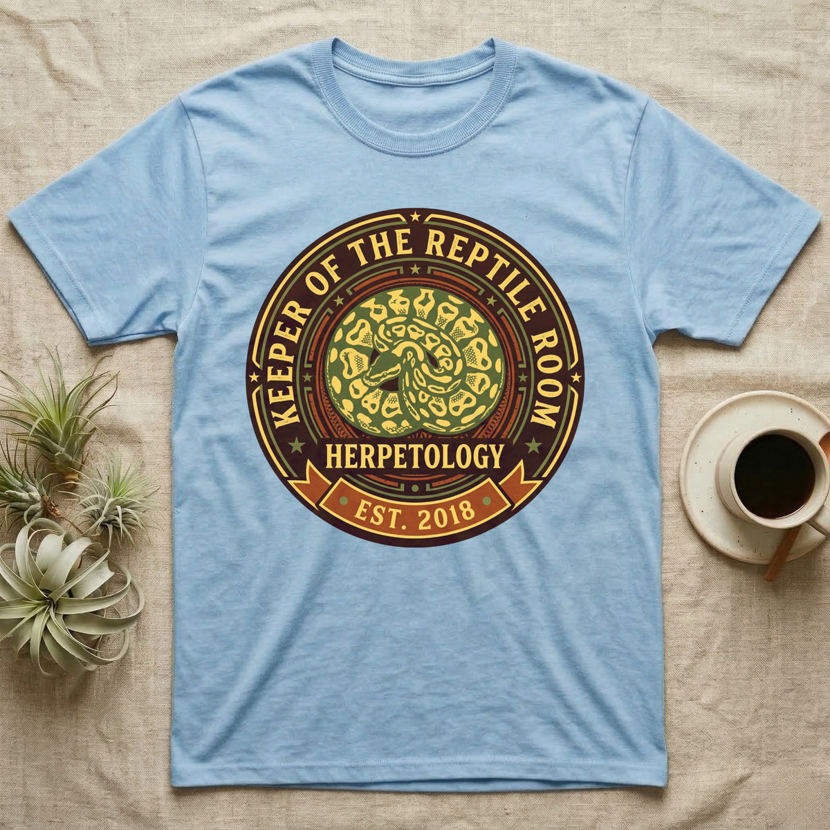 Blue t-shirt with "Keeper of the Reptile Room Herpetology Est. 2018" circular logo.