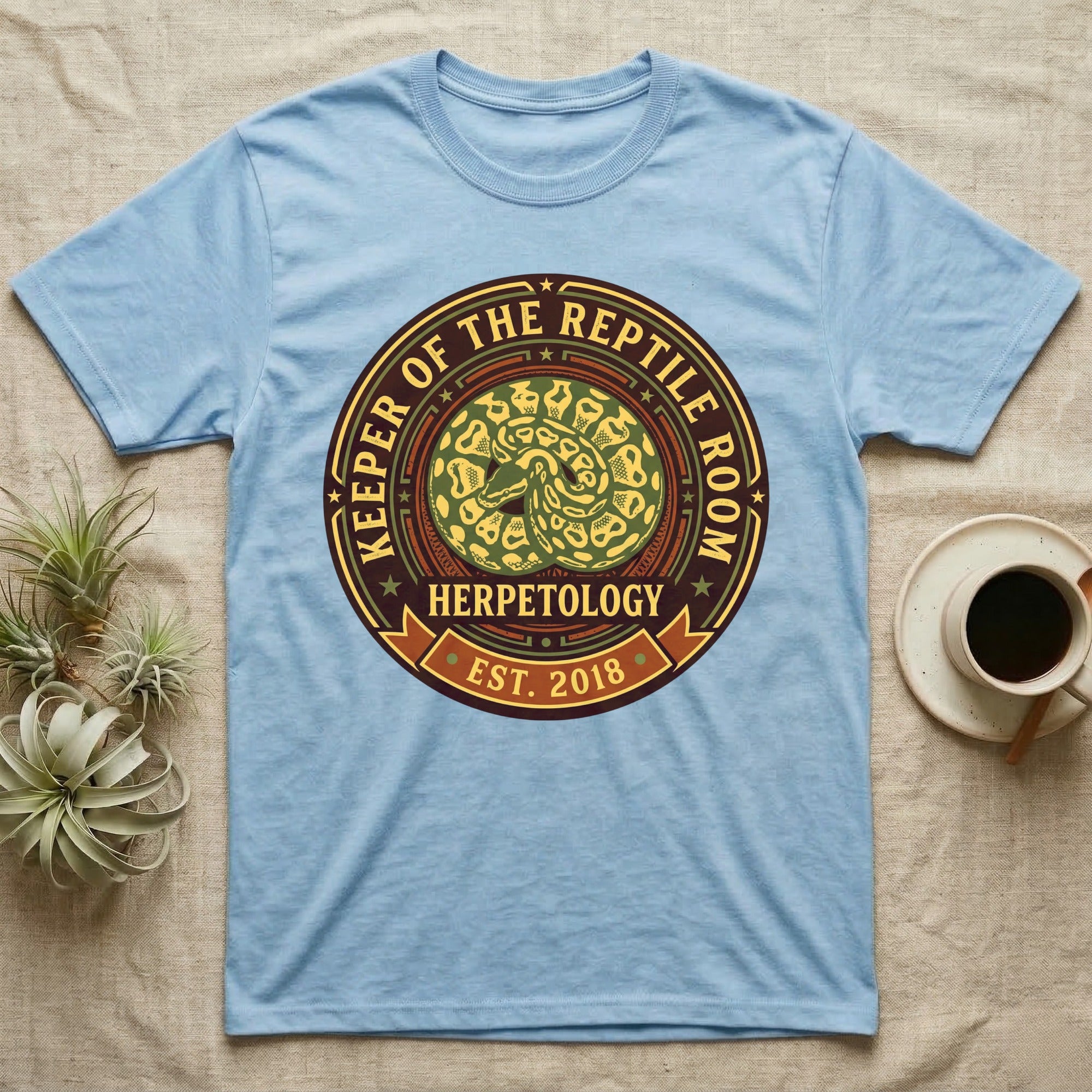 Blue t-shirt with "Keeper of the Reptile Room Herpetology Est. 2018" circular logo.