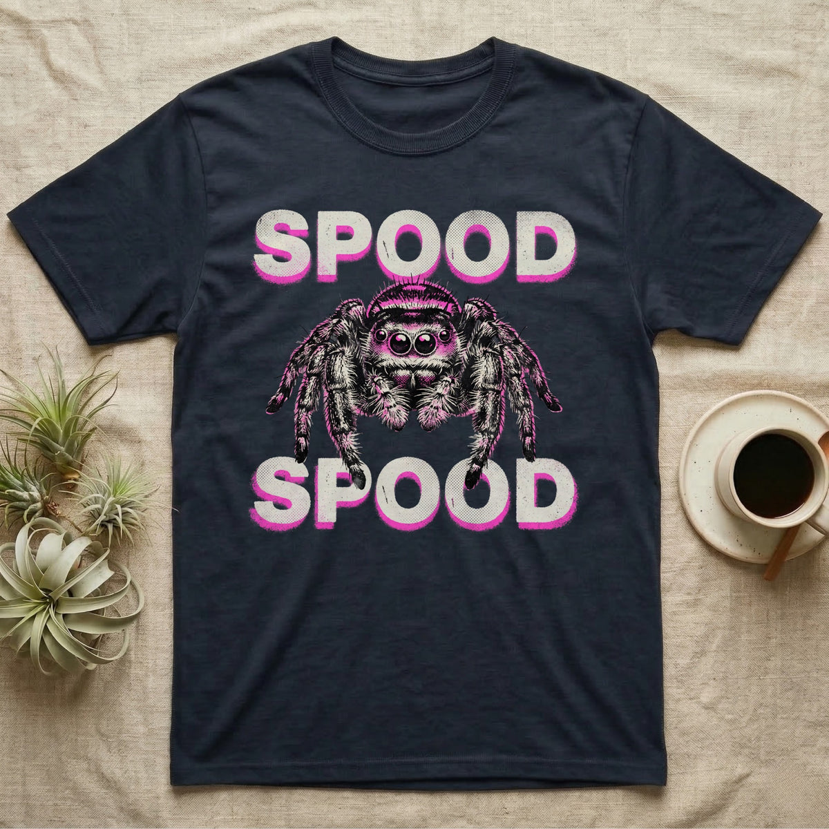 Spood Jumping Spider T-Shirt in Navy — Grunge-punk illustration of an oversized front-facing jumping spider with a distressed "Spood" wordmark in bone and acid pink.