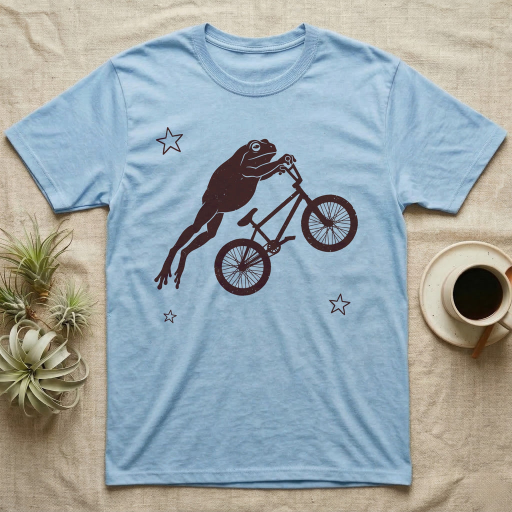 Tree Frog BMX T-Shirt in Light Blue — One-ink worn screen print of a White's tree frog riding a BMX bike mid-air, body stretched straight out behind the handlebars.