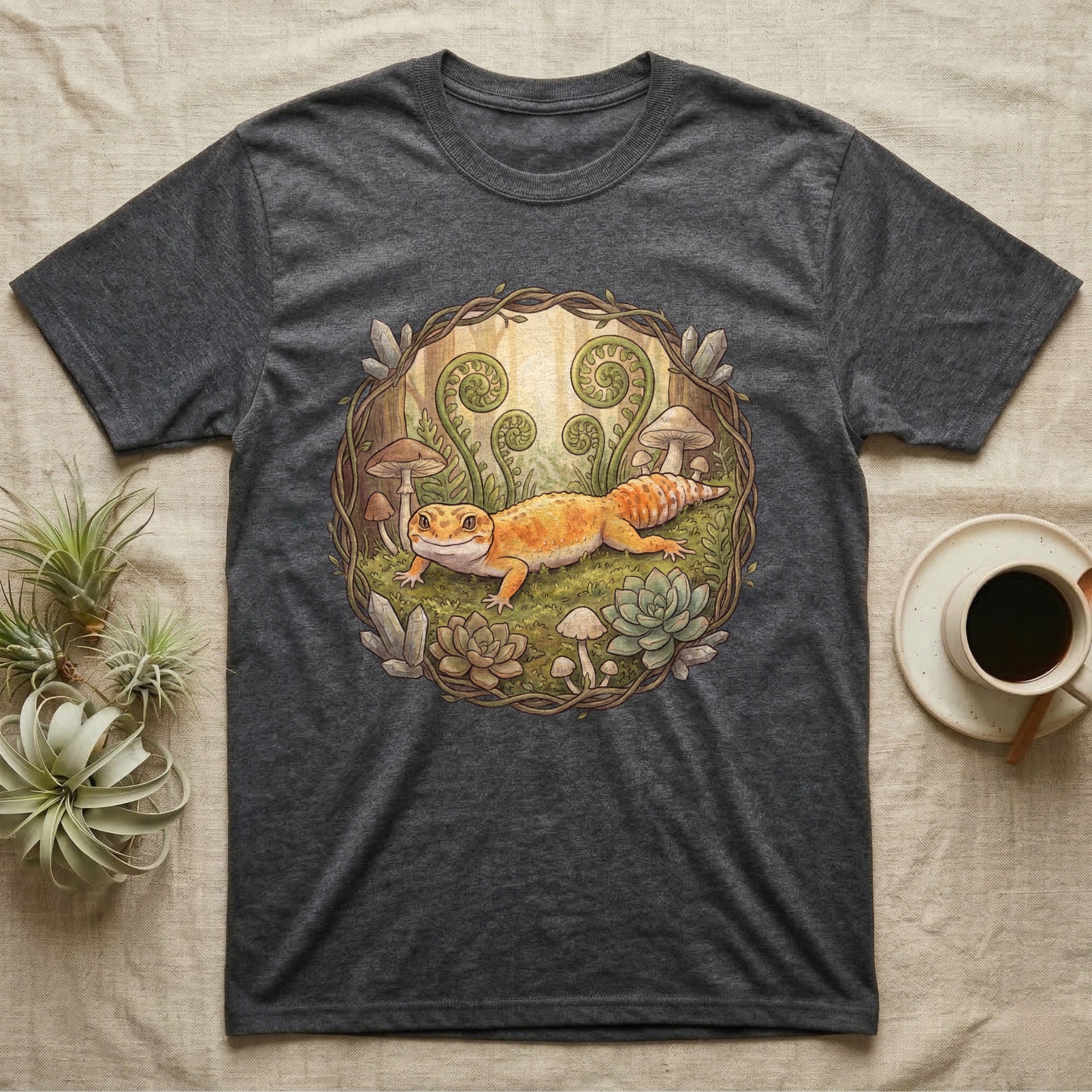 Dark grey t-shirt featuring a vibrant illustration of a leopard gecko with mushrooms and plants.