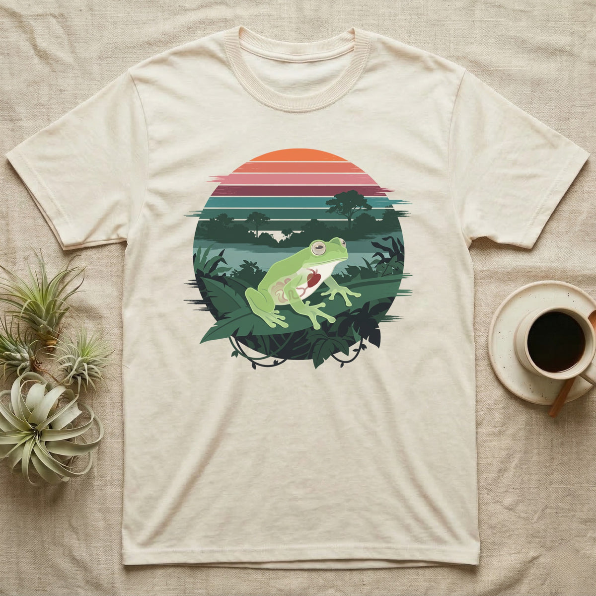 Glass Frog See-Through T-Shirt in Natural — Flat-colour circle-window illustration of a glass frog silhouetted crossing a rainforest canopy scene.