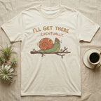 Cream t-shirt with a snail on a branch and text "I'll get there...eventually."