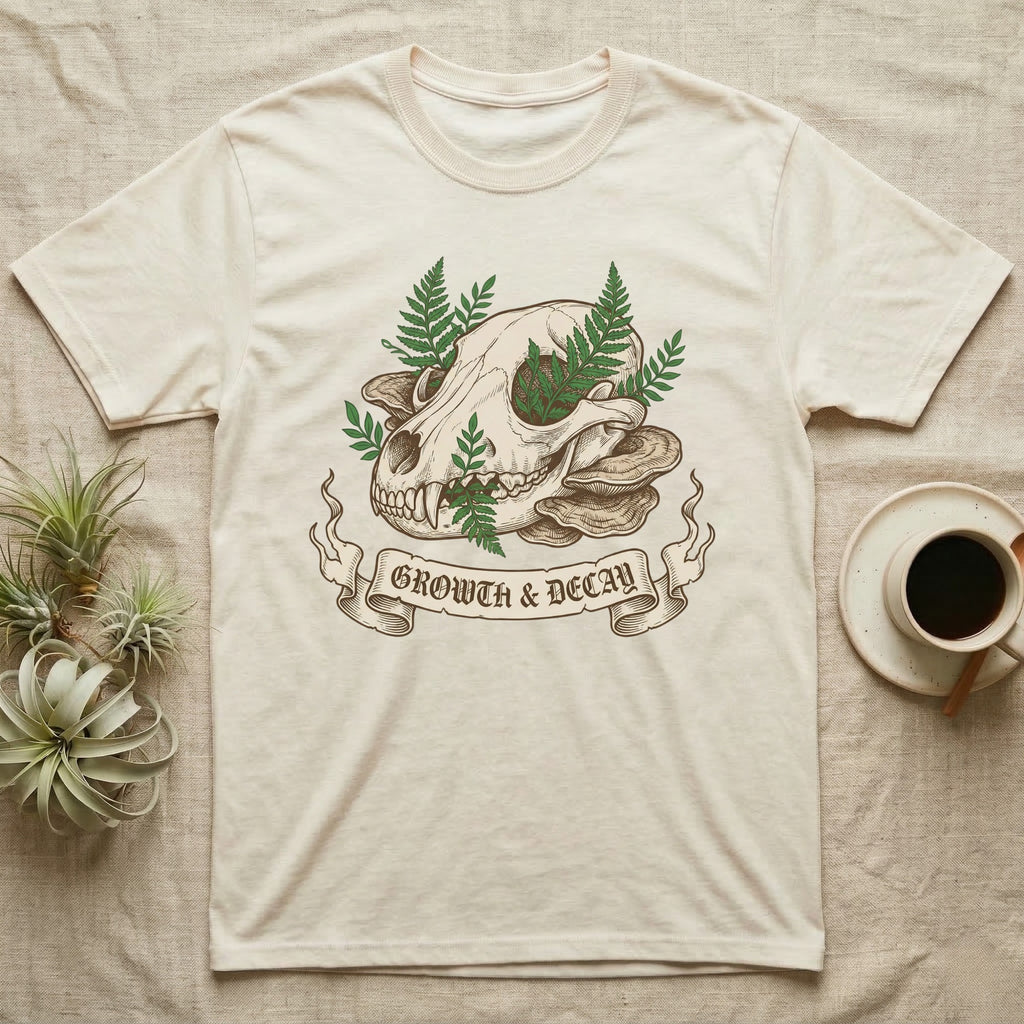 Cream t-shirt with skull, mushrooms, ferns, and "Growth & Decay" ribbon.