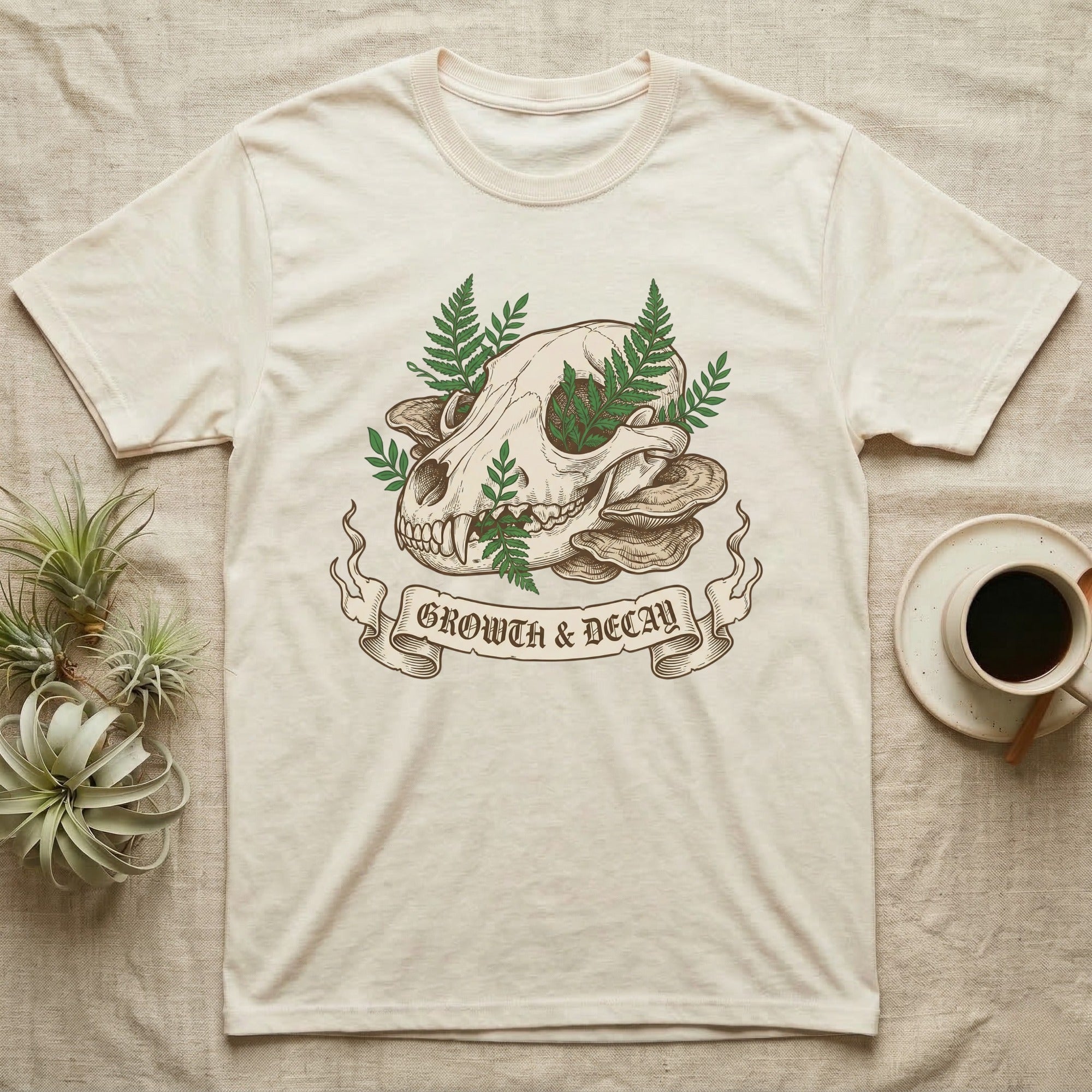 Cream t-shirt with skull, mushrooms, ferns, and "Growth & Decay" ribbon.