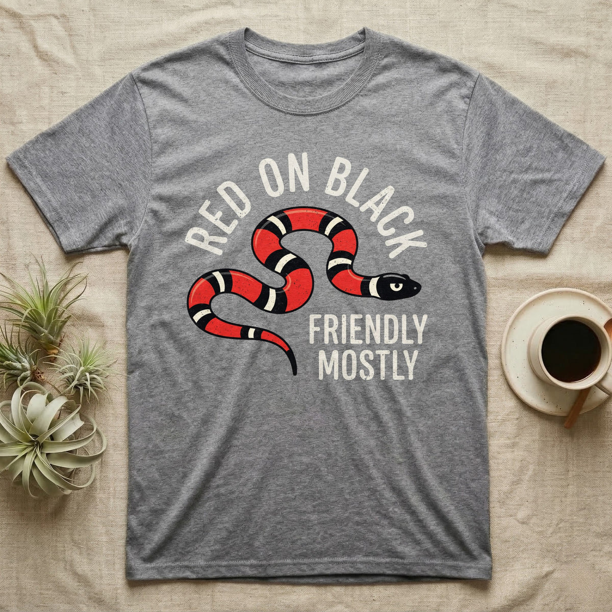 Milk Snake Friendly T-Shirt in Sport Grey — Worn screen-print of a red, black and cream banded milk snake under the cream words Red On Black, Friendly, Mostly