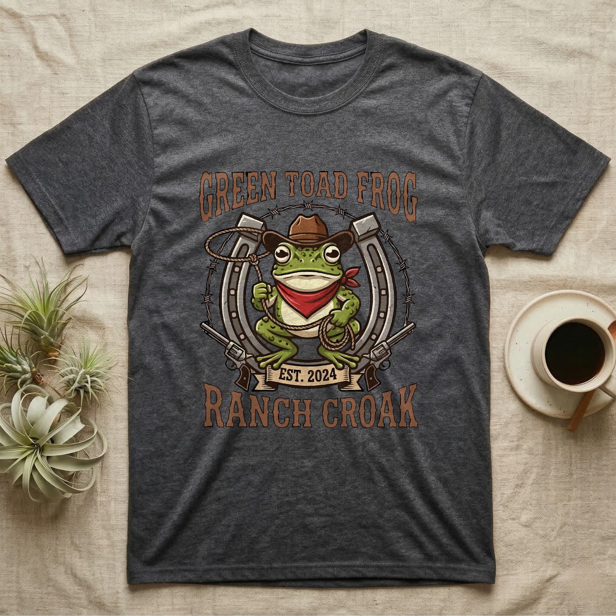 Dark gray t-shirt with cartoon frog wearing a cowboy hat and holding a lasso.