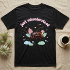 Madagascar Hissing Cockroach Baby T-Shirt in Black — Pastel Madagascar hissing cockroach among leaves, mushroom and moss, puffy pink wordmark "just misunderstood" above.