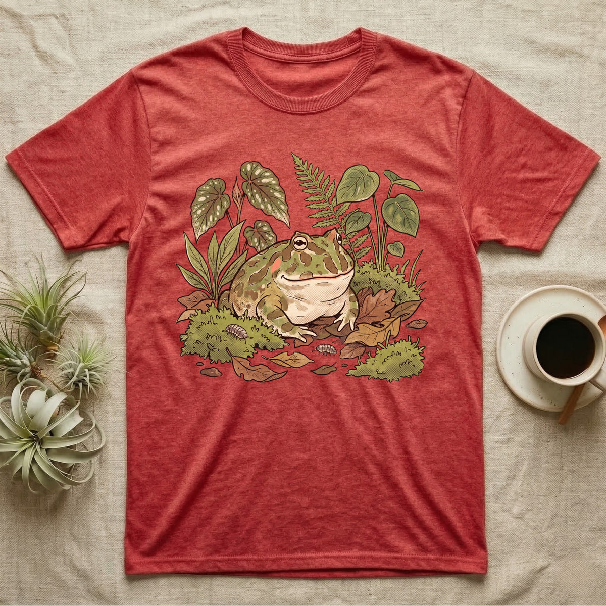 Bioactive Pacman Frog T-Shirt in Heather Red — Warm botanical illustration of a content pacman frog half-buried in a lush bioactive habitat of moss and leaf litter.