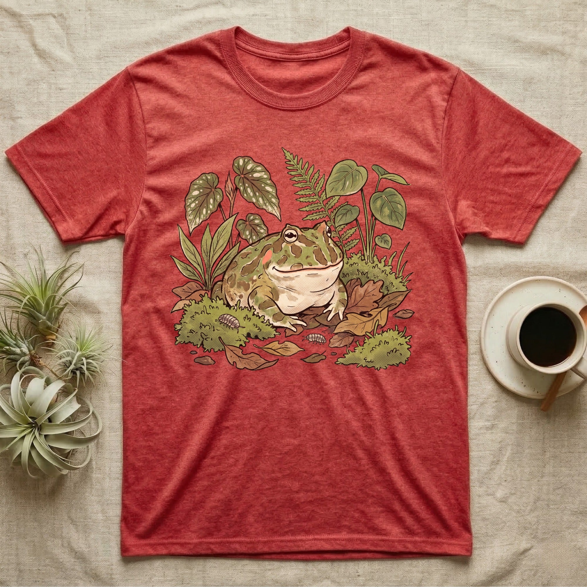 Bioactive Pacman Frog T-Shirt in Heather Red — Warm botanical illustration of a content pacman frog half-buried in a lush bioactive habitat of moss and leaf litter.