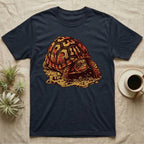 Vintage ink illustration of an Eastern box turtle crawling across sandy pebbles, high-domed shell shown in rust-red and amber, no on-shirt text. — shown on a Navy tee.
