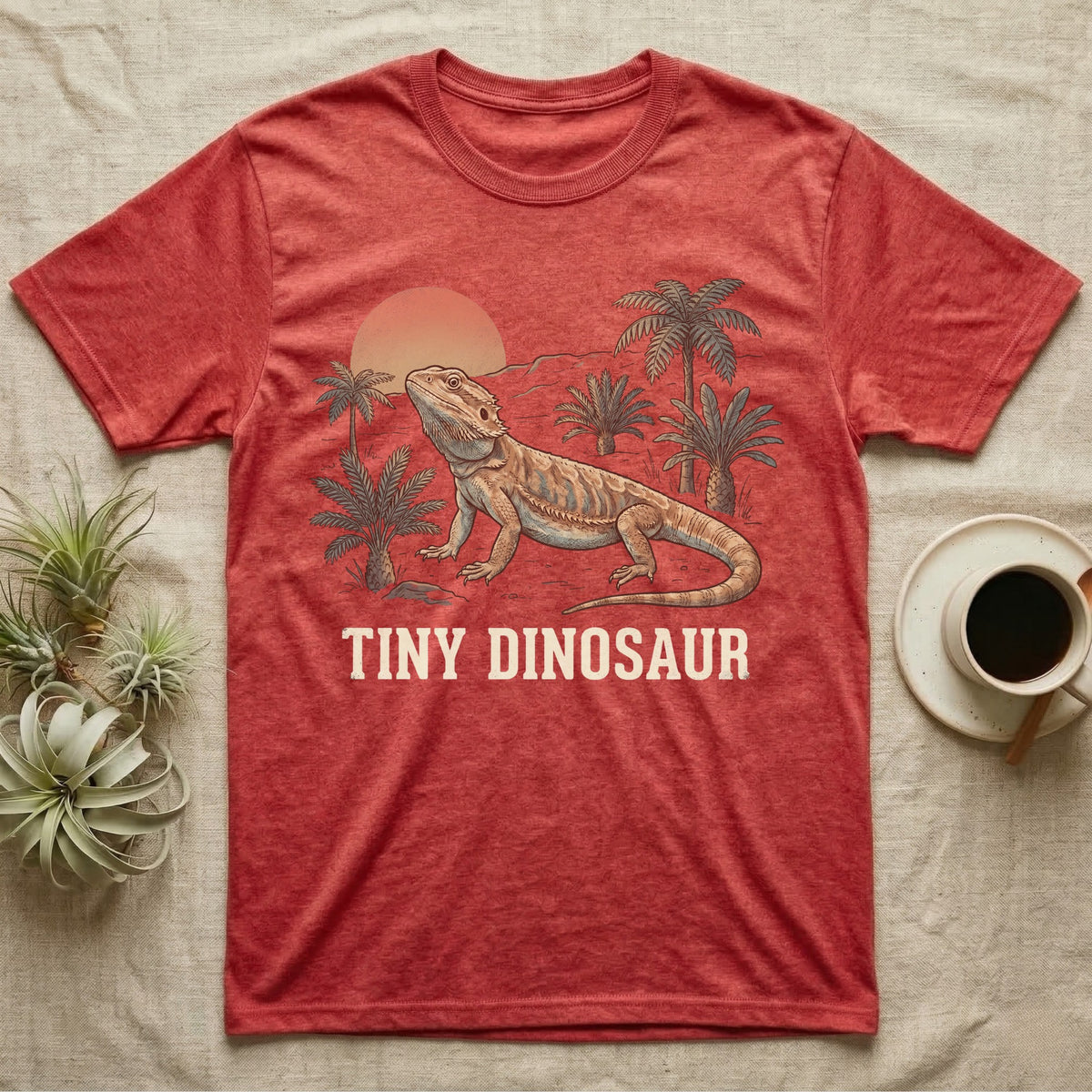 Tiny Dinosaur Bearded Dragon T-Shirt in Heather Red — Retro natural-history illustration of a bearded dragon in profile in a prehistoric landscape with a distressed "Tiny Dinosaur" caption.