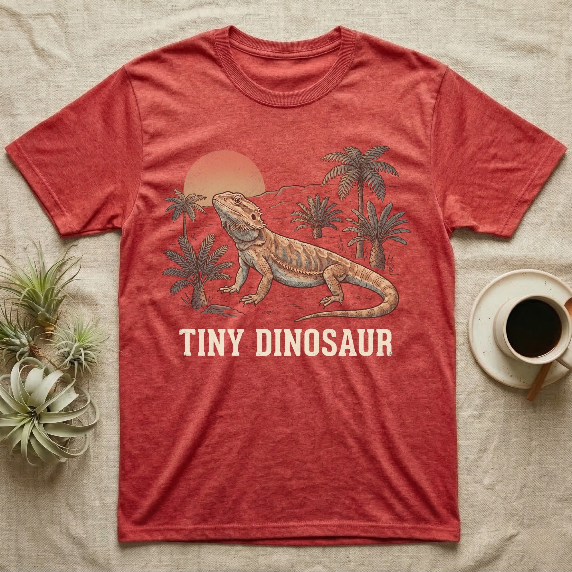 Tiny Dinosaur Bearded Dragon T-Shirt in Heather Red — Retro natural-history illustration of a bearded dragon in profile in a prehistoric landscape with a distressed "Tiny Dinosaur" caption.