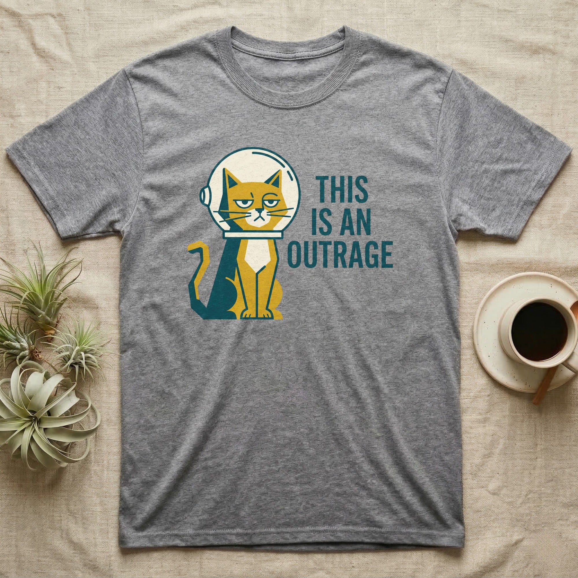 Grey t-shirt with a cartoon cat in a spacesuit and the text "THIS IS AN OUTRAGE".