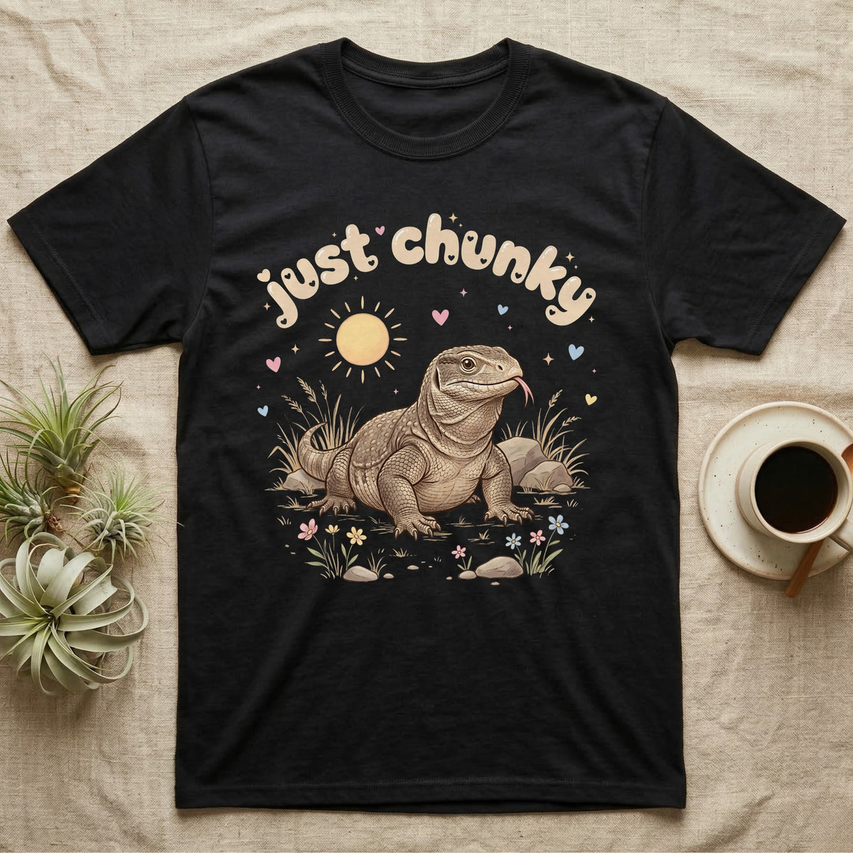 Savannah Monitor Softie T-Shirt in Black — Plump savannah monitor lizard with flicking tongue under pastel bubble text "just chunky" and hearts.