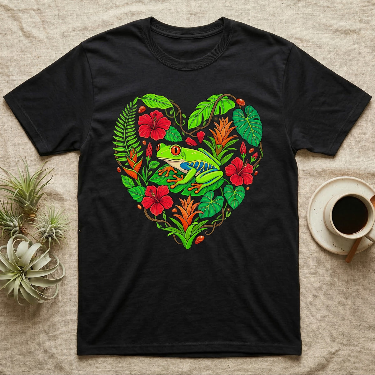 Black t-shirt with a colorful heart of tropical plants and a red-eyed tree frog.