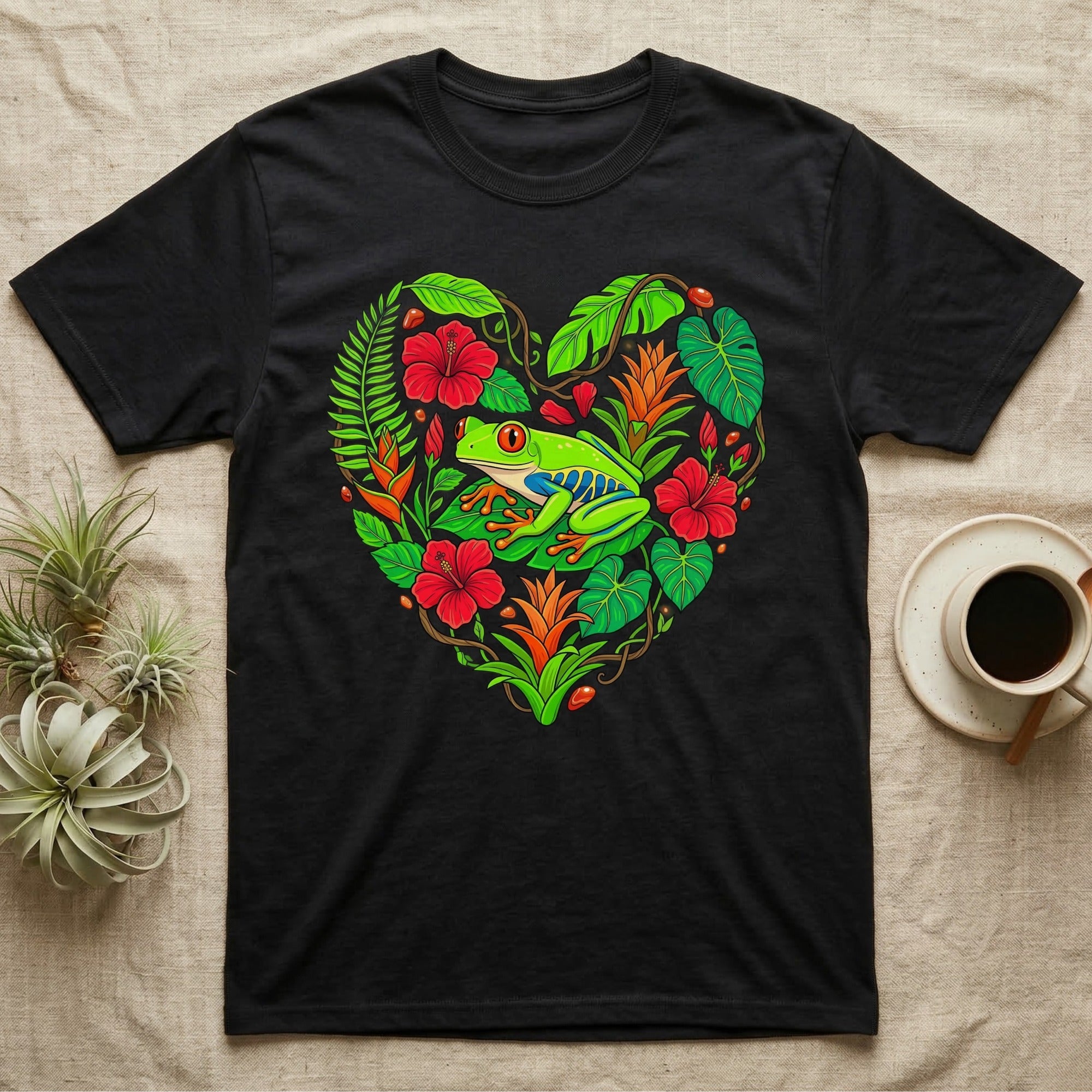 Black t-shirt with a colorful heart of tropical plants and a red-eyed tree frog.