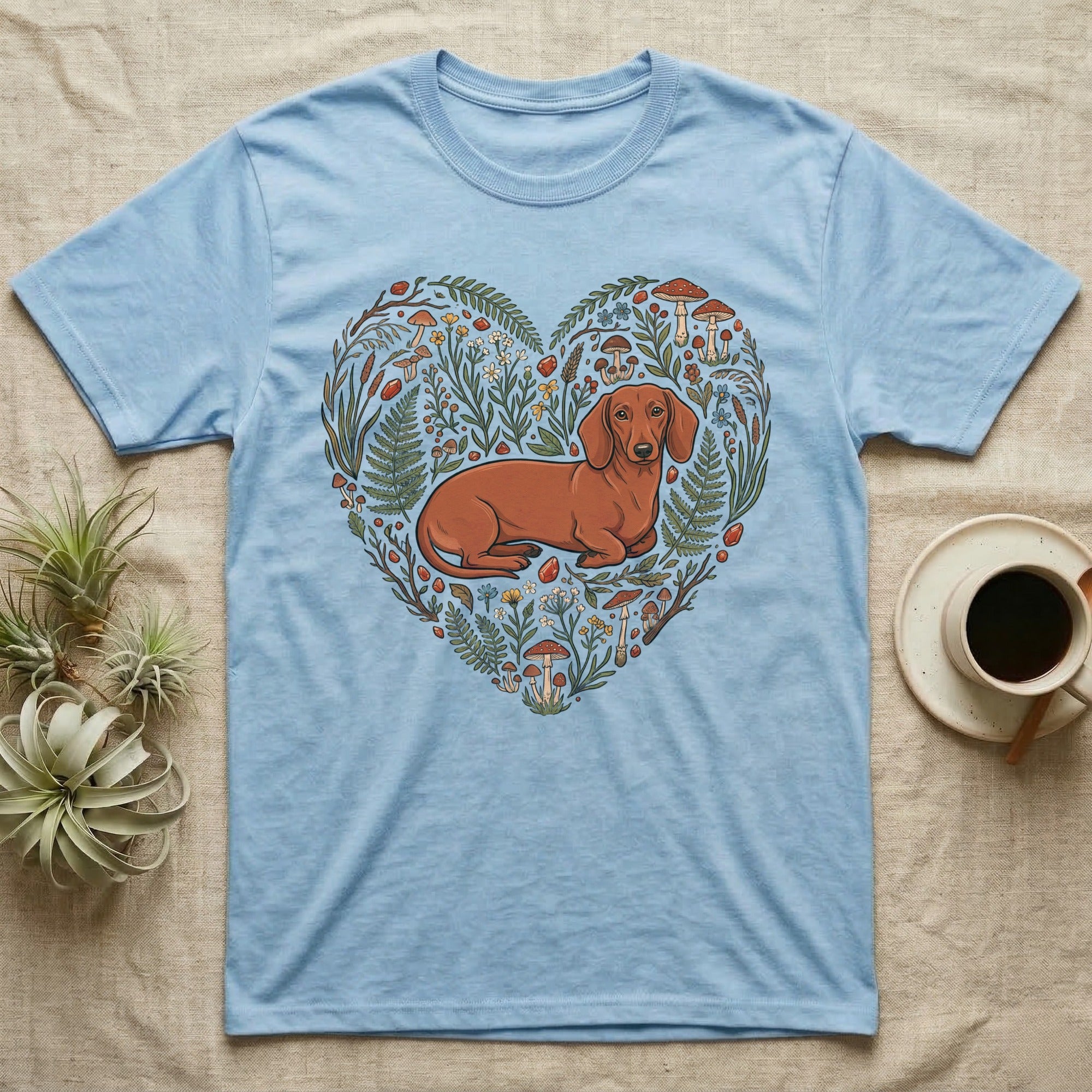 Light blue t-shirt with a dachshund illustration surrounded by a floral heart.