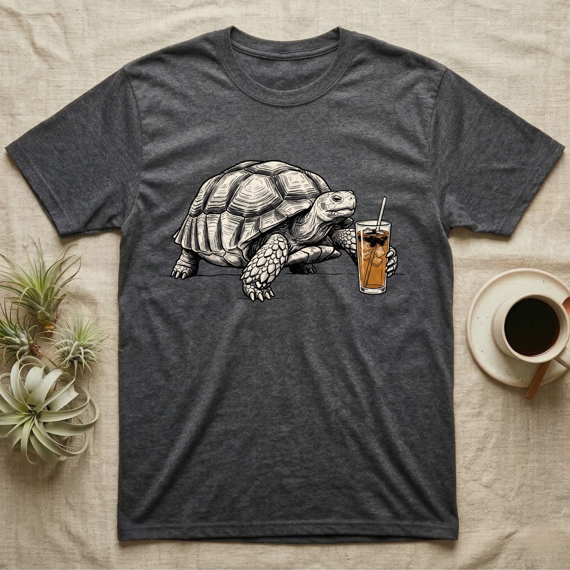 Slow Drip Tortoise T-Shirt in Dark Heather — Flat meme-style illustration of a sulcata tortoise reaching slowly toward a tall iced slow-drip coffee.