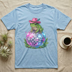 Frog in pink cowboy hat sits on disco ball with ferns.