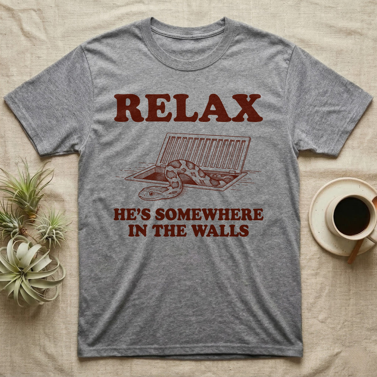 Corn Snake Walls T-Shirt in Sport Grey — Engraved corn snake looking out of an open floor vent, with the words Relax, He's Somewhere in the Walls