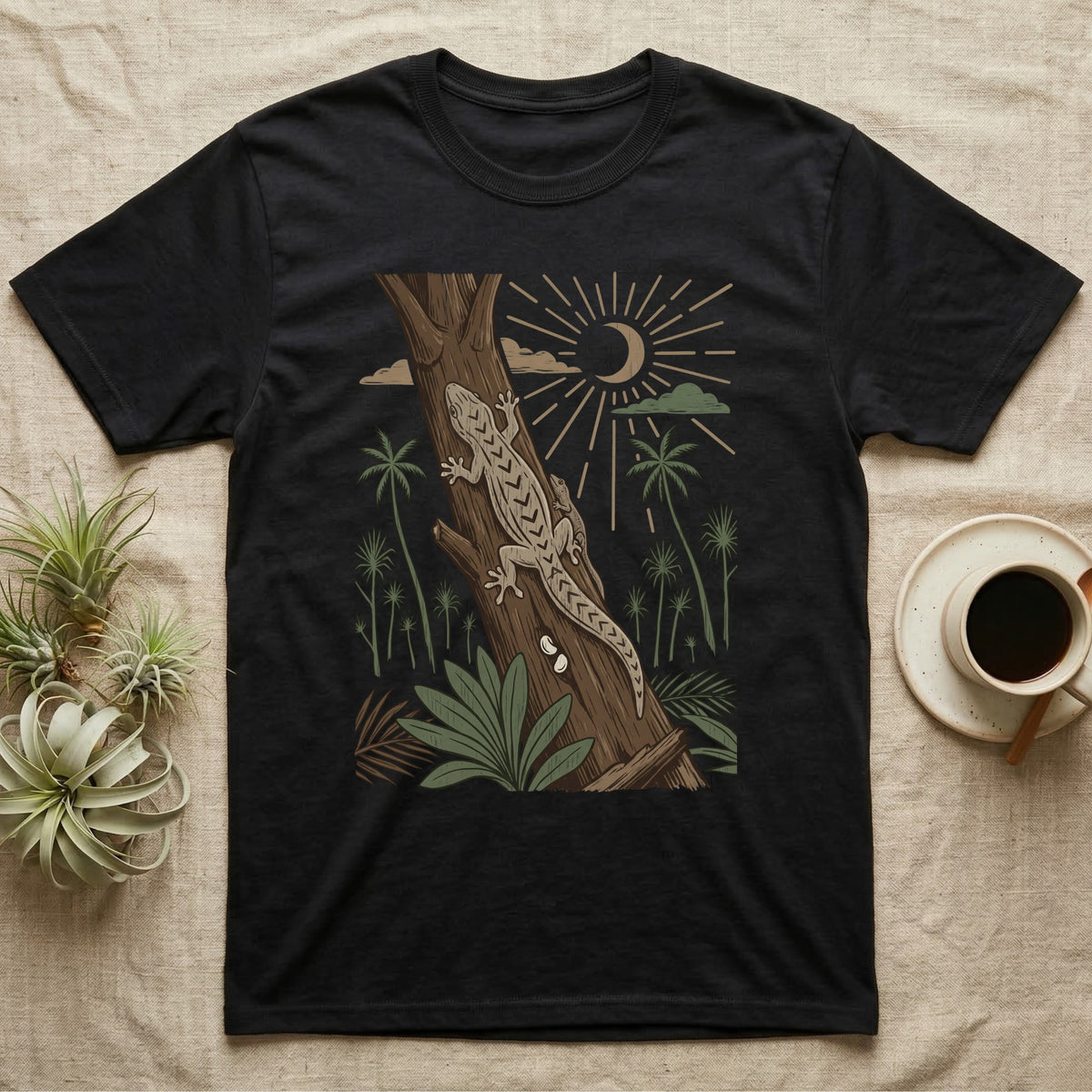 Mourning Gecko Home Range T-Shirt in Black — Woodcut-style illustration of two mourning geckos on a palm trunk with a pair of eggs in the bark and palms behind, no on-shirt text.