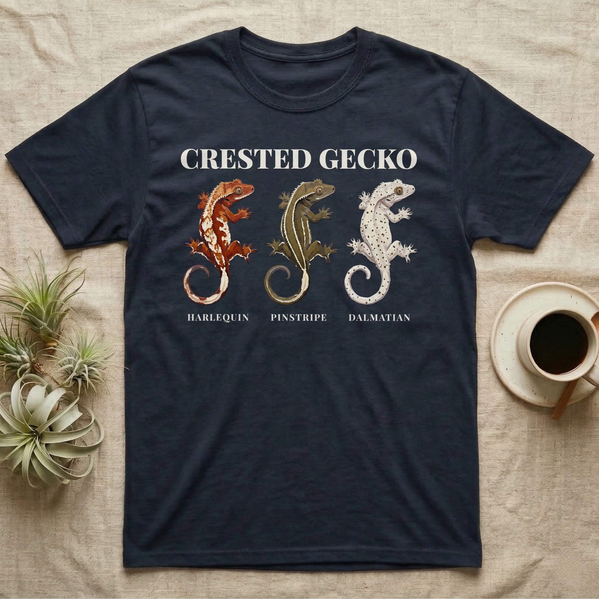 Crested Gecko Morph Chart T-Shirt in Navy — Impasto painted chart of three crested gecko morphs — harlequin, pinstripe and dalmatian — labelled beneath each gecko.