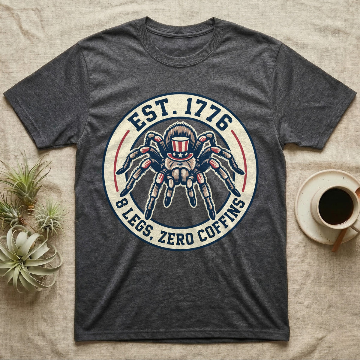 Tarantula Zero Coffins T-Shirt in Dark Heather — Circular patch emblem of a tarantula in a top hat with arched text Est. 1776 and 8 Legs Zero Coffins.