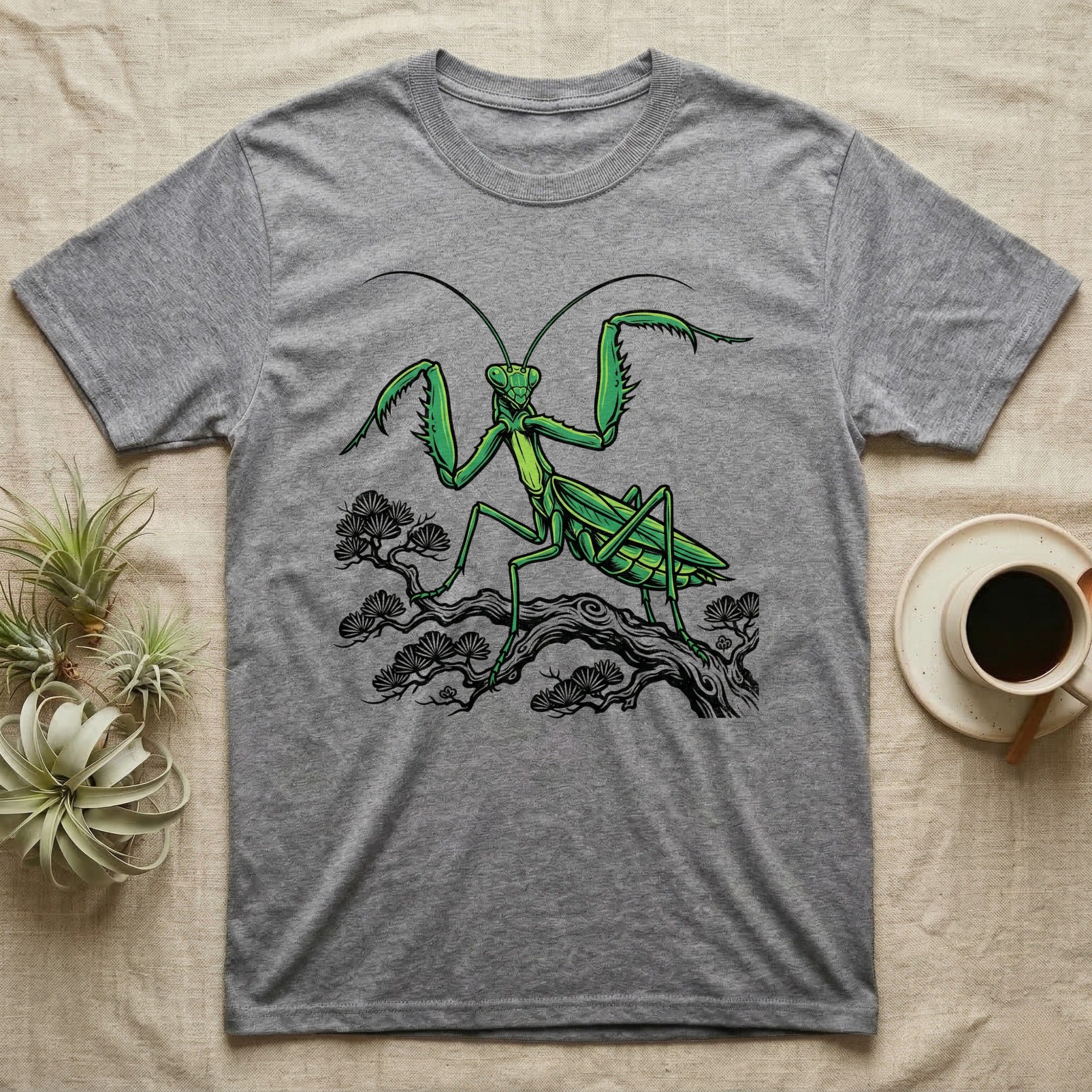 Gray t-shirt with a green praying mantis illustration on a tree branch.