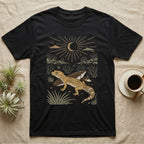 Leopard Gecko Home Range T-Shirt in Black — Woodcut-style illustration of a leopard gecko standing on cracked earth beside flat stones with thorn scrub behind, no on-shirt text.