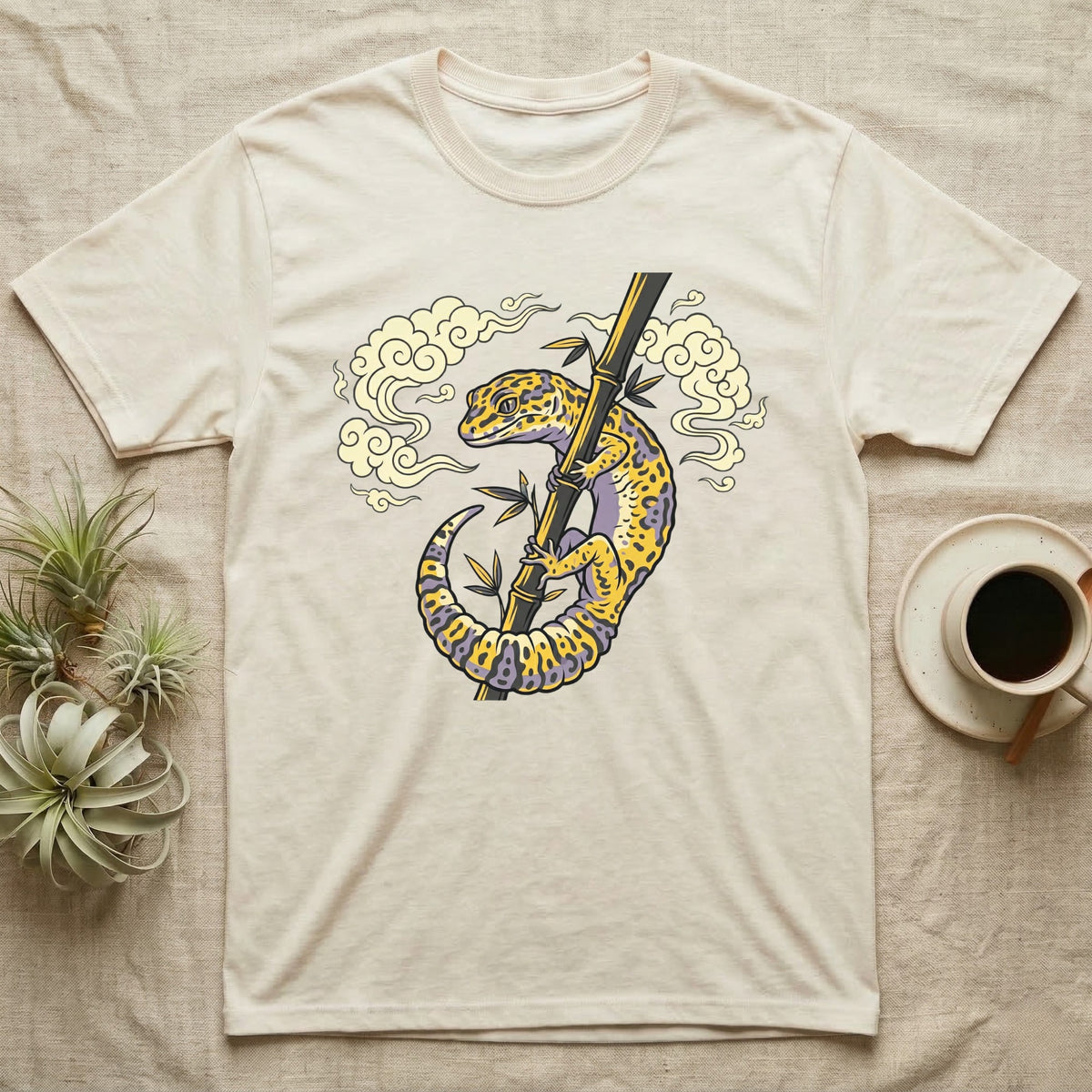 T-shirt featuring a stylized leopard gecko on bamboo with clouds.