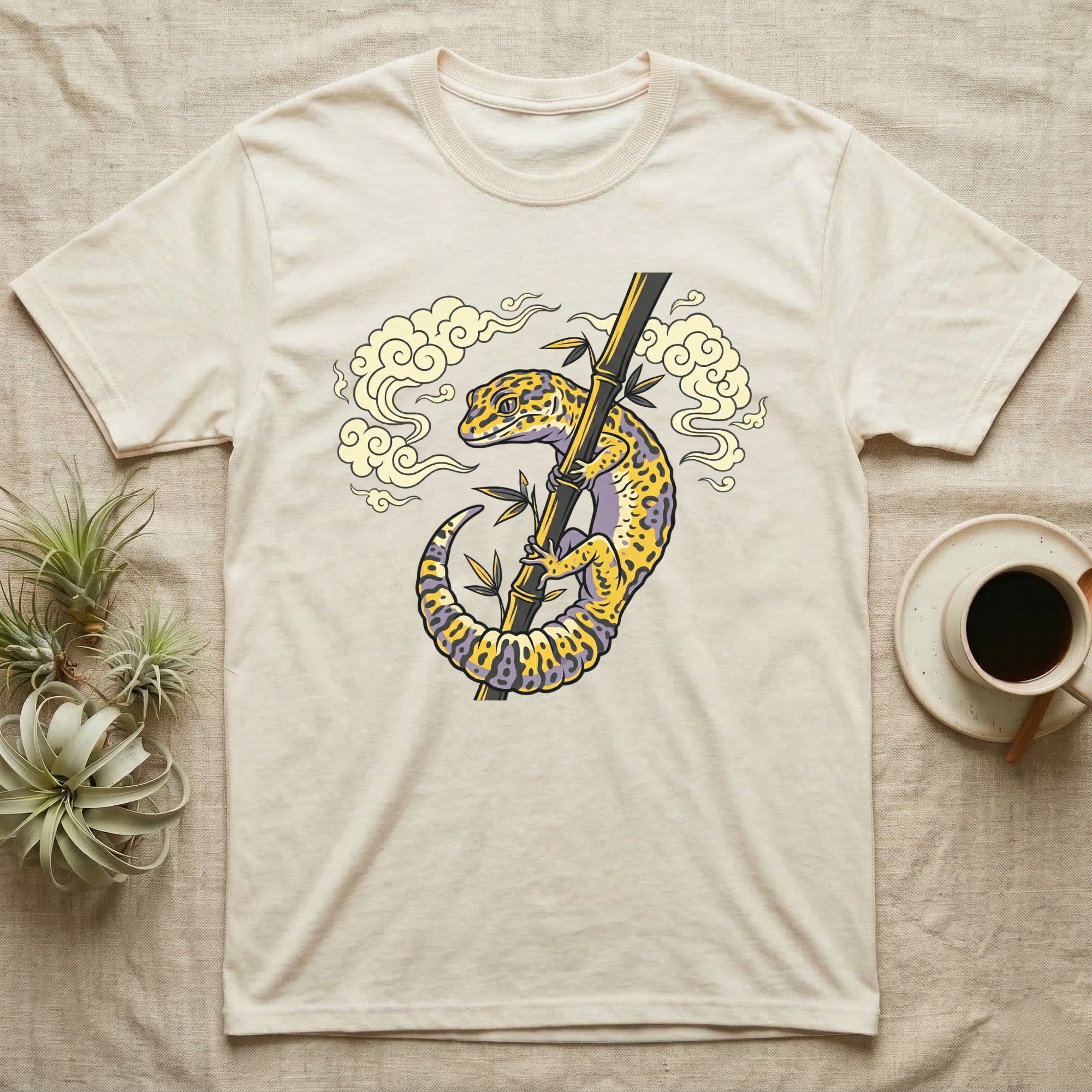 T-shirt featuring a stylized leopard gecko on bamboo with clouds.
