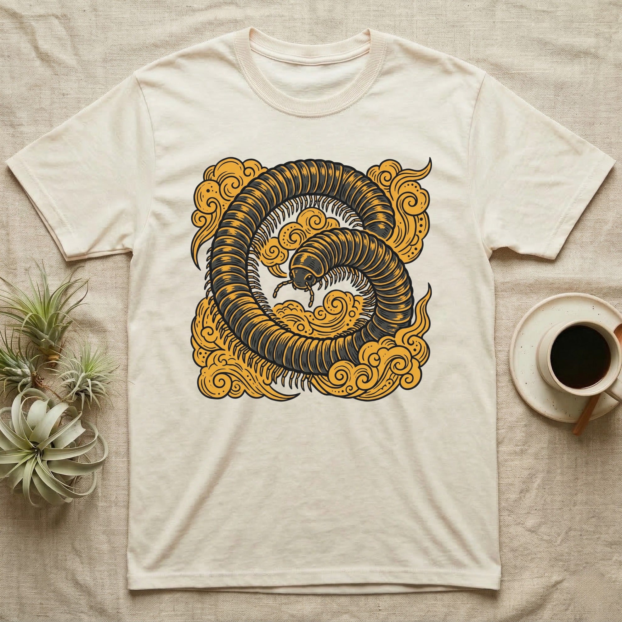 Cream t-shirt with a stylized millipede in a cloud design.