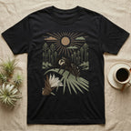 Jumping Spider Home Range T-Shirt in Black — Woodcut-style illustration of a regal jumping spider perched on a saw palmetto blade with pines behind, no on-shirt text.