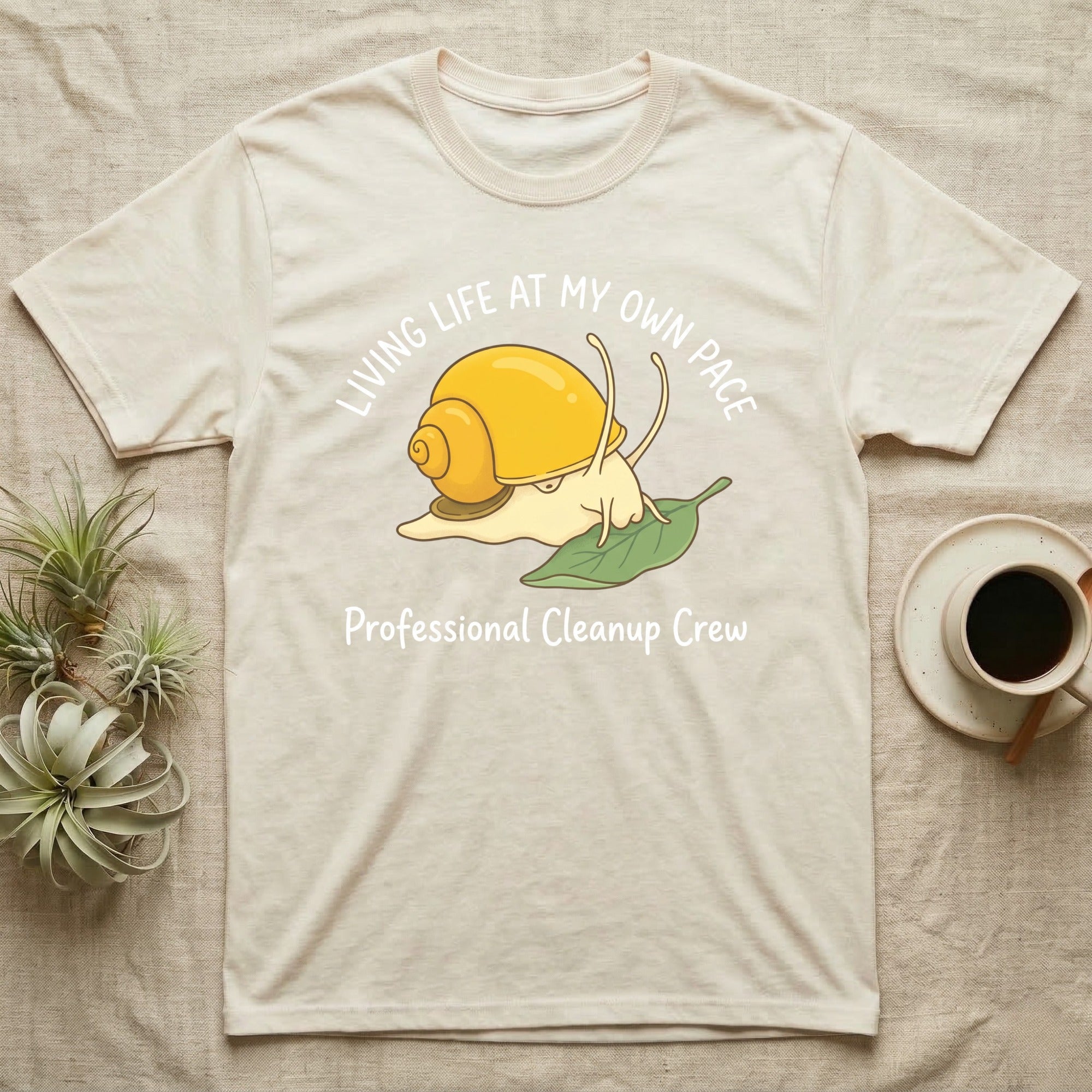 T-shirt with a yellow snail on a green leaf and text "Professional Cleanup Crew".