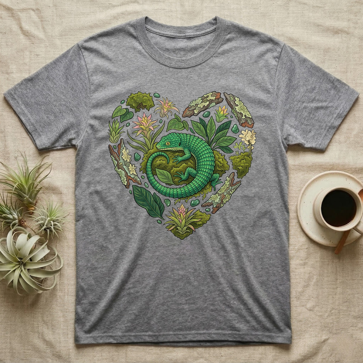 Grey t-shirt with a green lizard surrounded by a heart-shaped botanical design.
