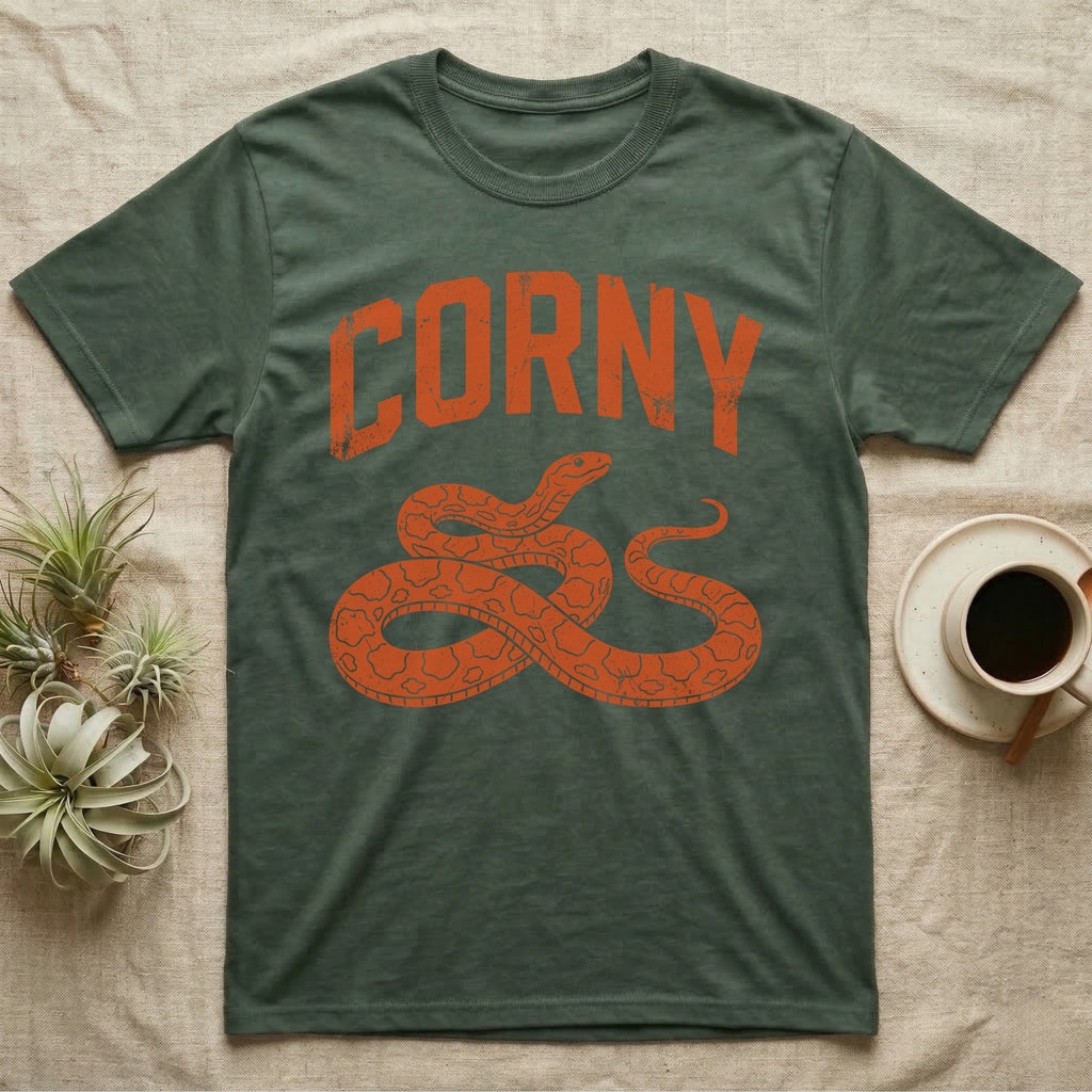 Corn Snake Corny T-Shirt in Military Green — Worn orange one-ink print of a corn snake lying in loose coils, head raised, under the arched word Corny