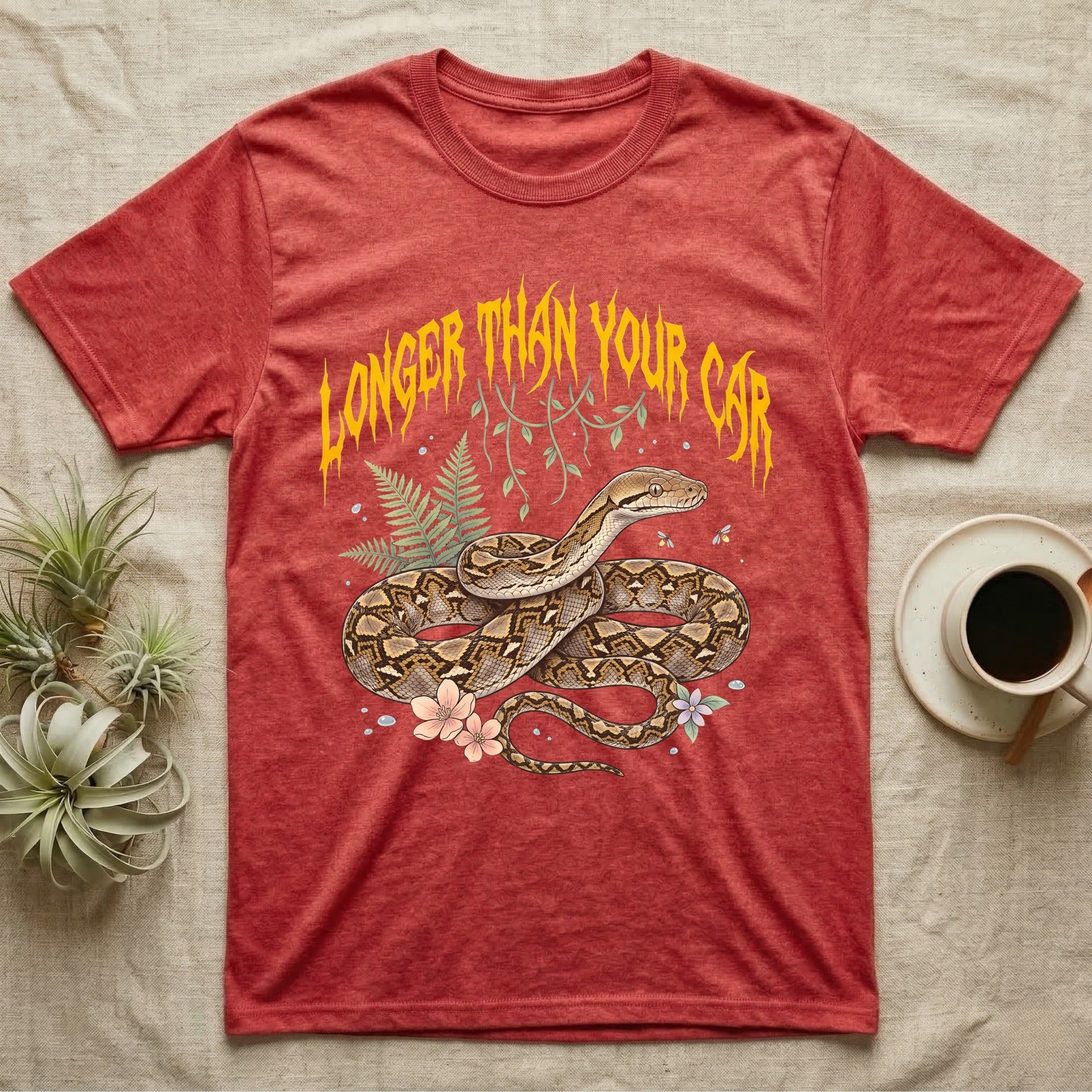Reticulated Python Feral T-Shirt in Heather Red — Reticulated python in net-patterned coils under jagged molten-gold metal text LONGER THAN YOUR CAR with pastel ferns