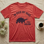 Musk Turtle Walking T-Shirt in Heather Red — Navy silhouette of a musk turtle walking under arched words In Over My Head, beside Still Walking