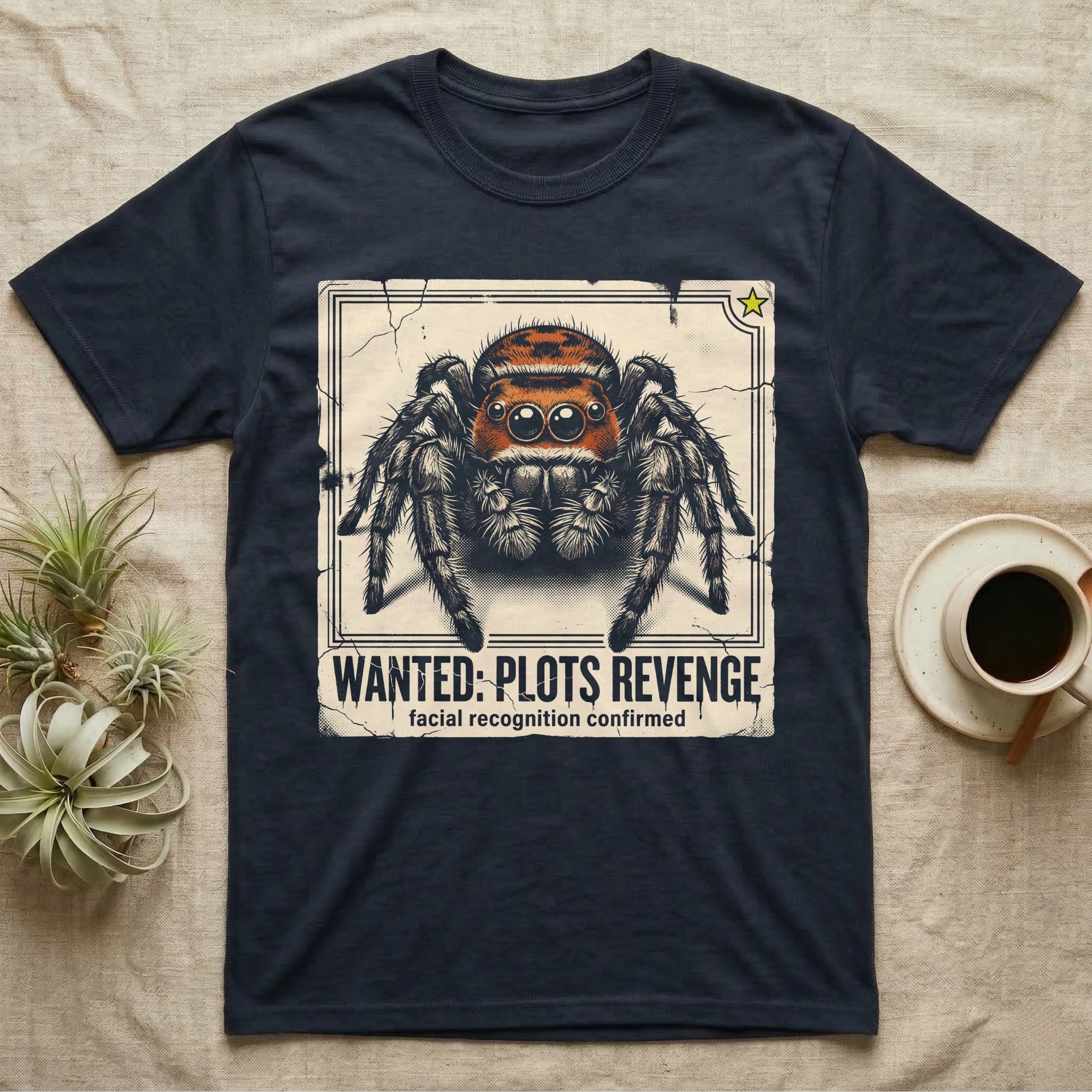 Jumping Spider Wanted T-Shirt in Navy — Distressed wanted-poster illustration of a front-facing jumping spider with the banner text plots revenge below.
